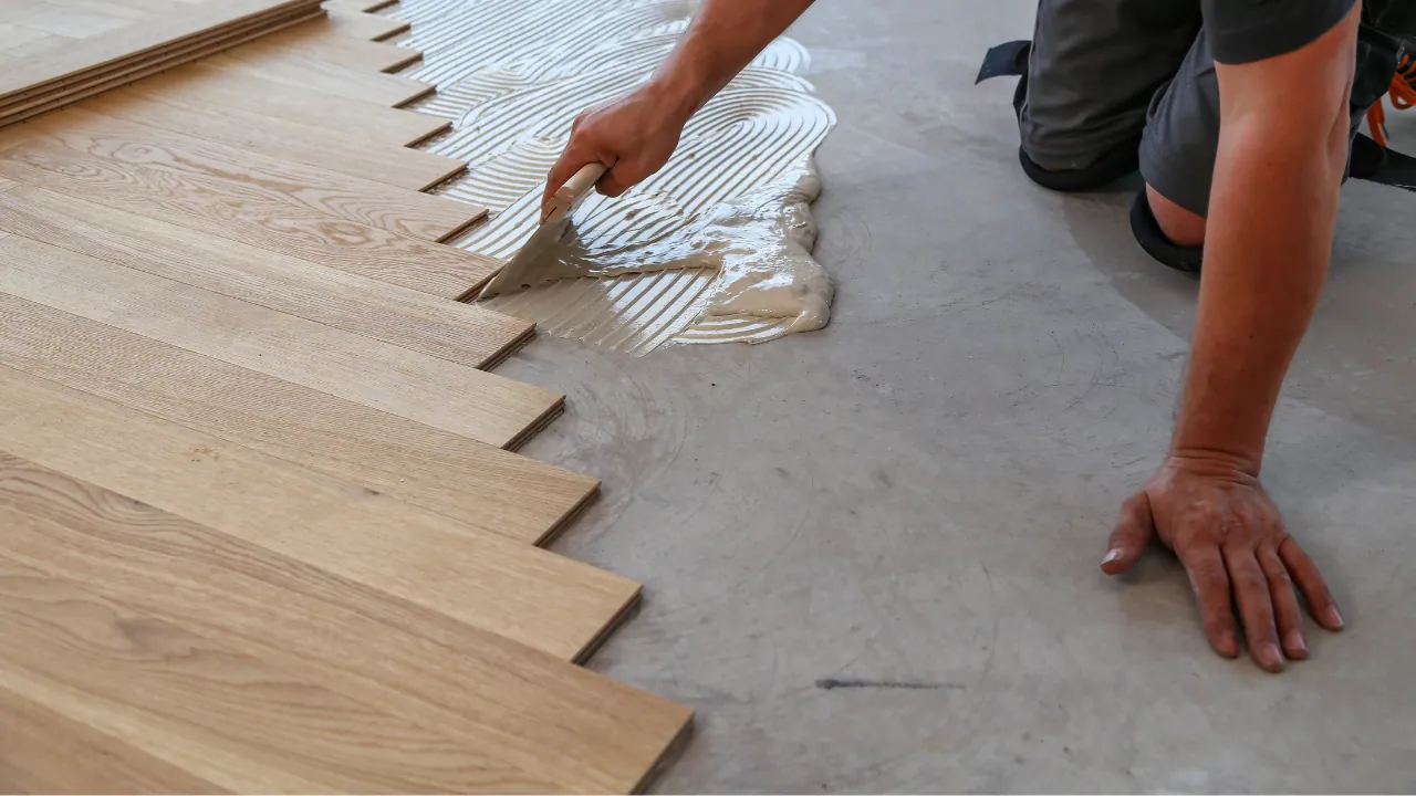 Installer fitting new plank flooring over a prepared subfloor