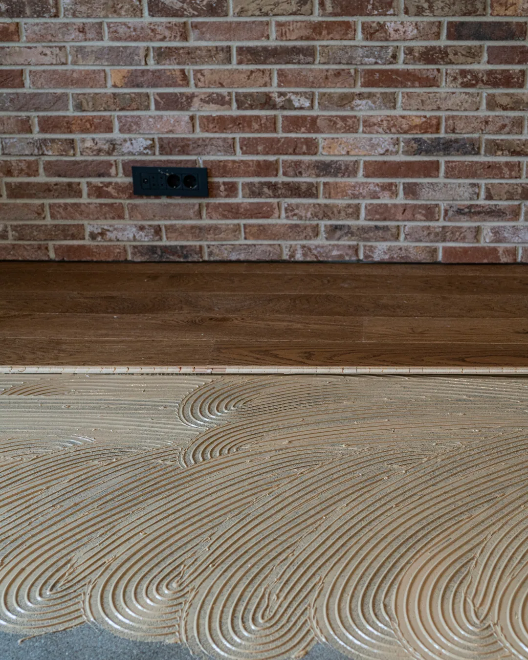 TFPros installer fitting wide-plank luxury vinyl flooring in a Fishers home